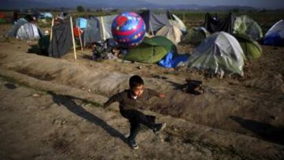 Boy plays with a ball at a makeshift camp for refugees and migrants at the Greek-Macedonian border near the village of Idomeni