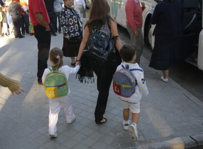 Una mujer lleva a sus dos hijos al colegio Sagrado Corazón en su primer día de clase, el curso pasado.