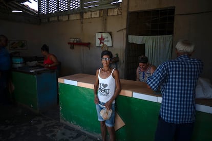 Surunvey Gonzalez poses for a photo at the government subsidized store, or "bodega," where she picked up her ration of bread in San Nicolas, Cuba, Friday, May 19, 2023