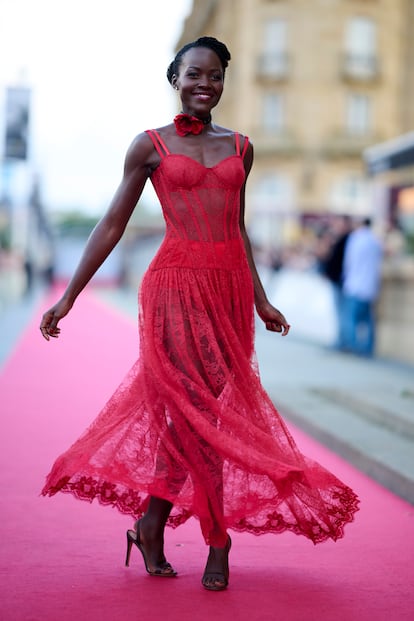 Lupita Nyong'o ha acudido al Festival de San Sebastián para promocionar su último trabajo, 'Robot Salvaje', una cinta de animación en la que pone voz a Roz. Para la ocasión apostó por los encajes y las transparencias con este sensual vestido rojo de Dolce & Gabbana que completó con una flor a modo de gargantilla.