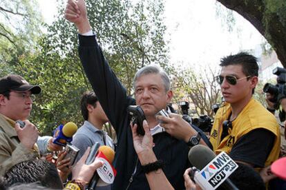 López Obrador saluda a sus seguidores mientras es abordado por periodistas en un parque cercano a su casa.