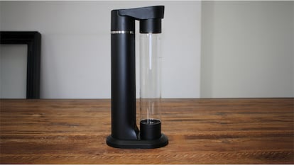 Máquina gasificadora de agua sobre una mesa de madera.
