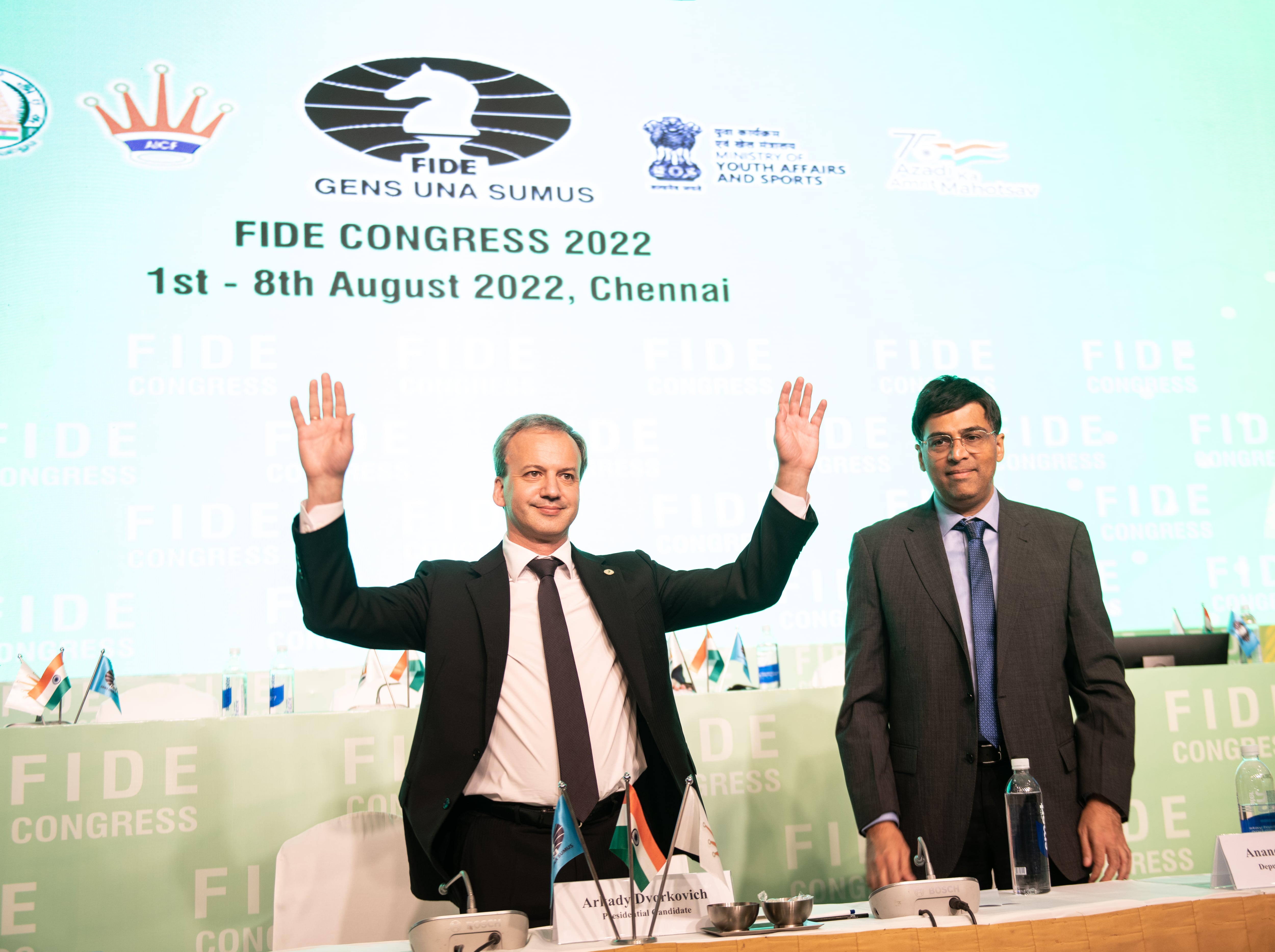 Dvorkóvich, acompañado por Anand, responde a los aplausos de los congresistas de la FIDE tras su reelección, en agosto de 2022 en Chennai