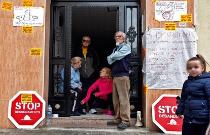 Gisela Bajo Quintana, con jersey rosa, junto a su madre, un familiar y un vecino, en el portal de su casa, en el barrio de La Torre, Valencia.