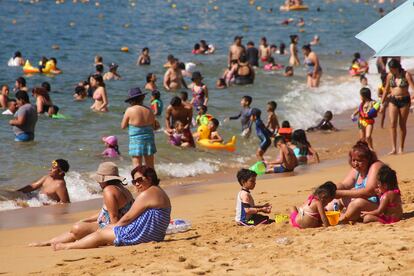 Turistas disfrutando del mar y la arena en una playa del Pacífico mexicano.