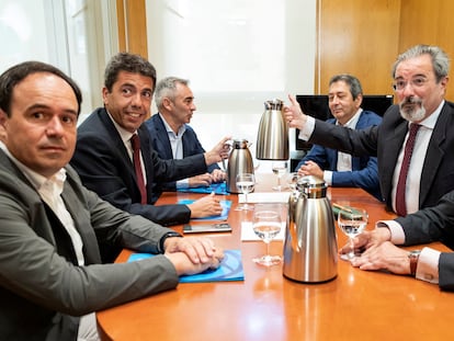 El próximo presidente de la Generalitat, Carlos Mazón, el segundo por la izquierda, frente al candidato de Vox, Carlos Flores, y sus equipos negociadores este martes en Valencia.