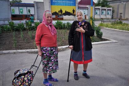 Zinaida (izquierda), de 75 años, y su cuñada Vera, de 80, en la plaza de Tomakivka, una de las localidades que reciben refugiados que escapan de los alrededores de la central nuclear de Zaporiyia.