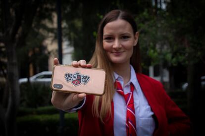 Milana Ždero muestra una calcomanía con el logo de RBD estampada en su teléfono móvil.