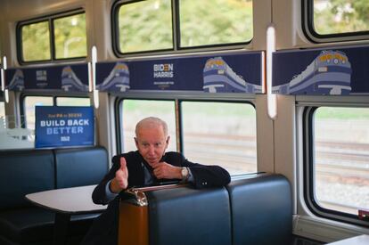 Joe Biden conversa con un profesor mientras se dirige en tren a un acto de campaña en Pittsburgh, Pensilvania, el 30 de septiembre.