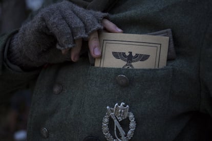 Un participoante en la recreación histórica en La Molina extrae del bolsillo de la guerrera su identificación militar de la época. La condecoración es el distintivo de asalto de infantería.