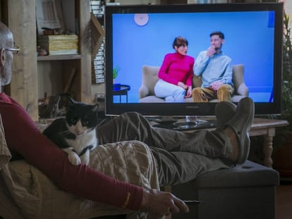 Un hombre ve la televisión en su casa. 