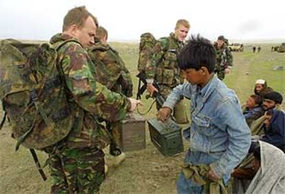 Un niño afgano ayuda a los <i>marines</i> británicos cerca de Kabul.