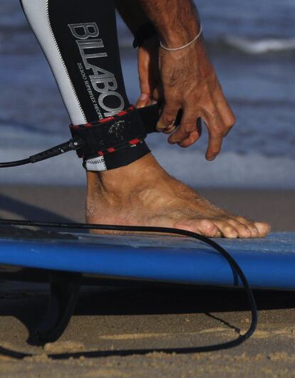 Playa de Bondi en Sydney. Uno de los muchos surfistas se ajusta el leash o pita al tobillo.