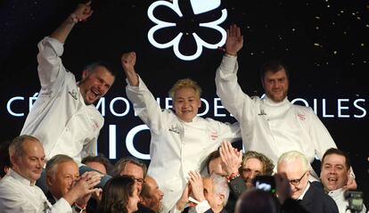 Los tres cocineros galardonados con tres estrellas Michelin, junto al resto de sus compañeros, en París, este lunes.