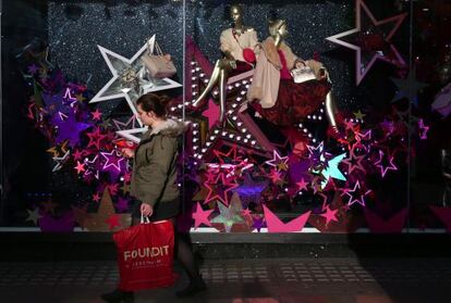Una mujer camina con un bolso de compras en Londres.