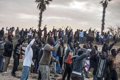 Inmigrantes en Melilla animan a sus compañeros durante el salto de la valla cerca de Beni Enza, 28 de marzo de 2014.