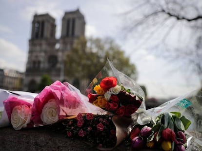 Flores dejadas por los transeúntes en el puente enfrente de Notre Dame, en París, hoy miércoles 17 de abril.