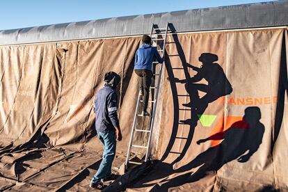 Trabajadores del 'Phelophepa' instalan un toldo en el costado del tren para poder recibir pacientes en una estadía de dos semanas en Thaba Nchu.