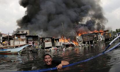 Un joven filipino escapa de un incendio en Paranaque, al sur de Manila (Filipinas).