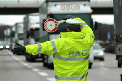 Un policía dirige el tráfico de camiones en el peaje de la ciudad alemana de Ludwigsfelde.