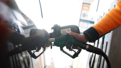 Un empleado echa di&eacute;sel en un autom&oacute;vil en una gasolinera en la carretera de Extremadura.  
 