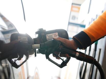 Un empleado echa di&eacute;sel en un autom&oacute;vil en una gasolinera en la carretera de Extremadura.  
 