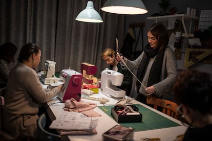 La profesora Begoña Plaza, de pie, da algunas directrices a los alumnos de la clase de costura de La Laborteca, un estudio en Madrid.