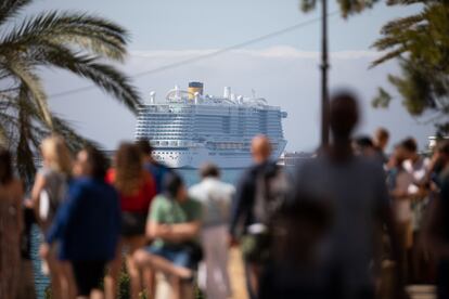 Turistas en las inmediaciones de la catedral de Palma. Al fondo, uno de los cruceros que llegan habitualmente a la isla.