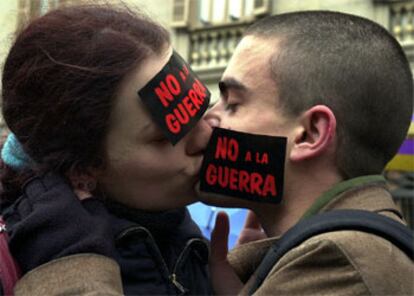 Algunas parejas de enamorados han querido celebrar el día de San Valentín con un beso y un no a la guerra.  Estos novios de Barcelona (Andre y Aisha) han participado en un acto en contra de la intervención militar en Irak. Sus mejillas lucían la ya famosa pegatina que portaron todos los asistentes a la pasada y polémica entrega de los premios Goya.