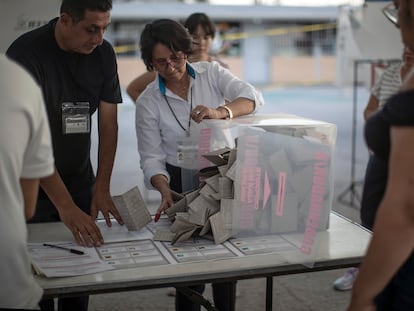Una funcionaria electoral vacía una urna para contar los votos, en el municipio mexiquense de Ecatpec