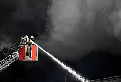 Bomberos trabajan para apagar un incendio en el centro comercial asiático Dong Xuan Center, centro de la actividad económica vietnamita en Berlín (Alemania).