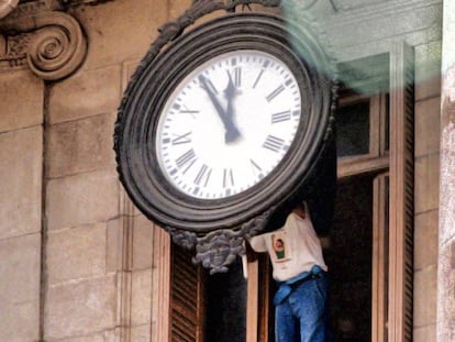 Un operario cambia la hora de un reloj del Ayuntamiento  de Barcelona.