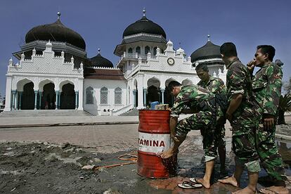 Soldados indonesios lavan sus manos y sus pies antes de entrar a la mezquita de Baiturrahman, en Banda Aceh, que ayer reabrió sus puertas.