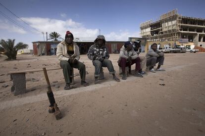 Trabajadores extranjeros se ofrecen para trabajar, mostrando sus herramientas en una carretera de Misrata, Libia.