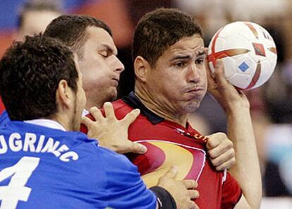 Uríos arma el brazo para lanzar el balón pese a ser agarrado por dos contrincantes.