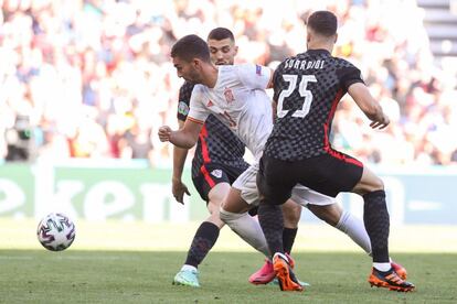 Dos jugadores de Croacia, el centrocampista Mateo Kovacic y el defensa Josko Gvardiol, disputan el balón ante el delantero de España Ferran Torres.