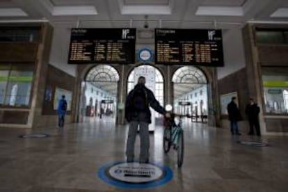 Un pasajero observa una pantalla con las llegadas y salidas previstas en la estación de trenes Santa Apolonia. EFE/Archivo
