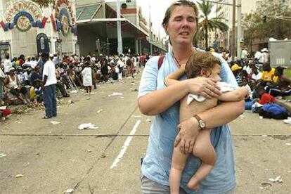 Una mujer con su hijo de 11 meses busca ayuda en el exterior del Centro de Convenciones de Nueva Orleans tras el paso del Katrina.