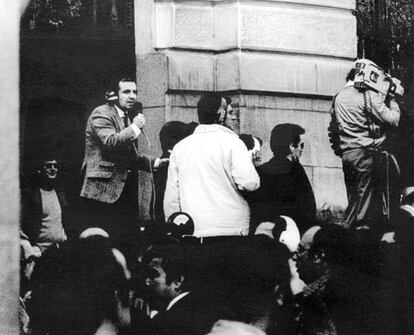 El periodista deportivo José María García (izquierda) informa desde las inmediaciones del Congreso, junto a otros reporteros, de los acontecimientos tras la ocupación militar de la Cámara.