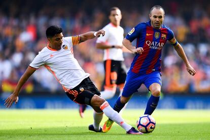 Andrés Iniesta del FC Barcelona competeix per la pilota amb Enzo Pérez del València CF.