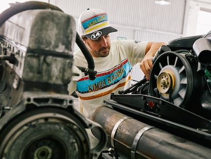 Un Fernando Alonso vestido de Kimoa, su firma de moda, revisa el motor del Alpine con el que volverá a competir por el Gran Premio.