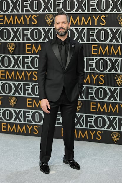 El actor Neil Druckmann, conocido por su papel en 'The last of us', con un clásico traje negro.