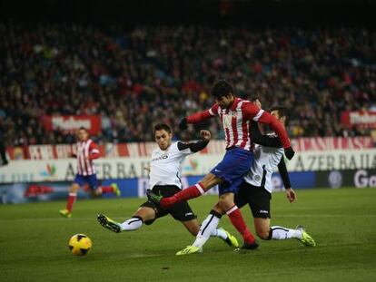 Valencia’s defenders bounce off Diego Costa last Sunday.