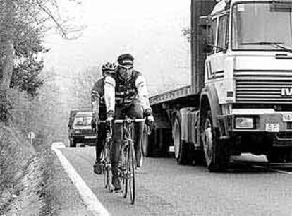 Un camión adelanta, traspasando la línea contínua, a los ciclistas profesionales Patxi Vila y Juanma Gárate durante uno de sus entrenamientos.