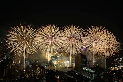 Fuegos artificiales explotan sobre el río Chao Phraya durante las celebraciones de Año Nuevo en Bangkok, Tailandia.