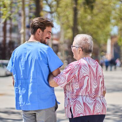 Rear view of a Caucasian old woman walking in the city with her internal nurse helper.