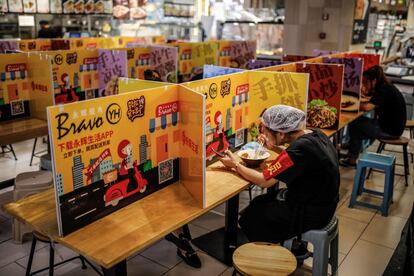 Dos empleadas de un supermercado comen guardando medidas de distanciamiento debido a la pandemia del coronavirus, en Pekín, China, este jueves, 25 de junio de 2020, día en el que se celebra el Festival del bote del dragón.