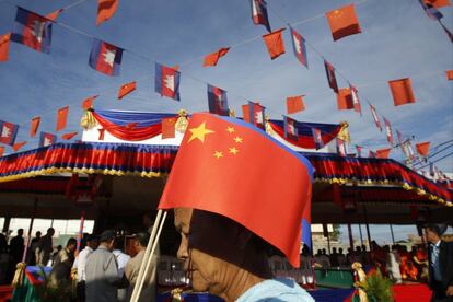 Una mujer camboyana sostiene una bandera China mientras camina por el puente de la amistad entre Camboya y China durante la ceremonia de inauguracin en Takhmao, de la provincia de Kandal, al sur de Phnom Penh, Camboya.