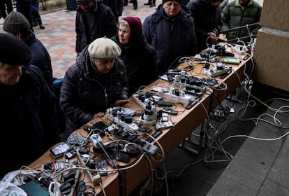 Un grupo de personas cargan sus móviles en un edificio público en Bucha. El espionaje alemán ha grabado conversaciones entre soldados rusos en Ucrania que presuntamente prueban que los disparos a civiles formaban parte de la estrategia de guerra del Kremlin en ese país, según ha informado este jueves el semanario 'Der Spiegel'.