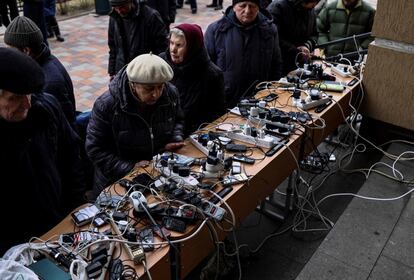 Un grupo de personas cargan sus móviles en un edificio público en Bucha. El espionaje alemán ha grabado conversaciones entre soldados rusos en Ucrania que presuntamente prueban que los disparos a civiles formaban parte de la estrategia de guerra del Kremlin en ese país, según ha informado este jueves el semanario 'Der Spiegel'.